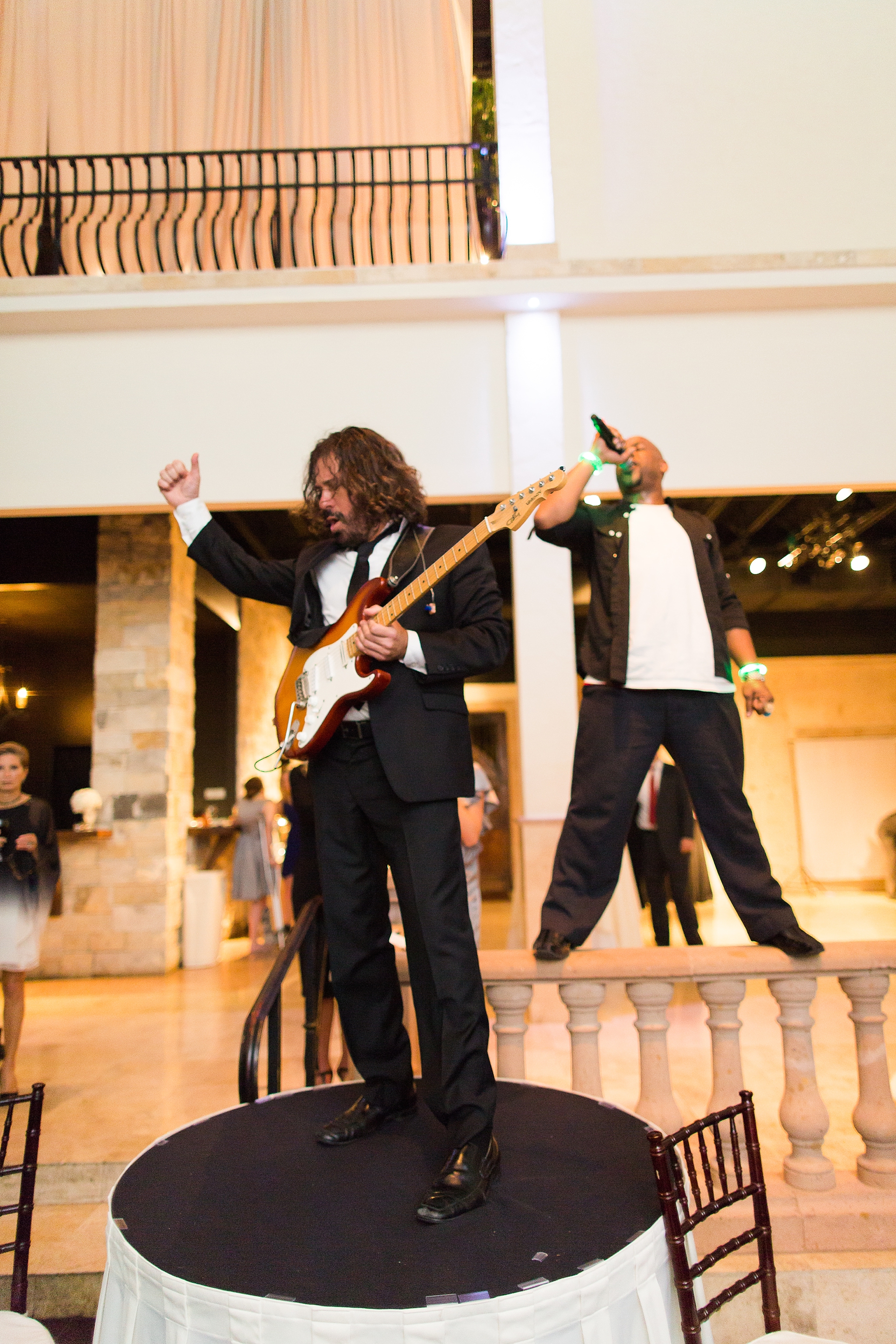 band standing on tables at wedding reception