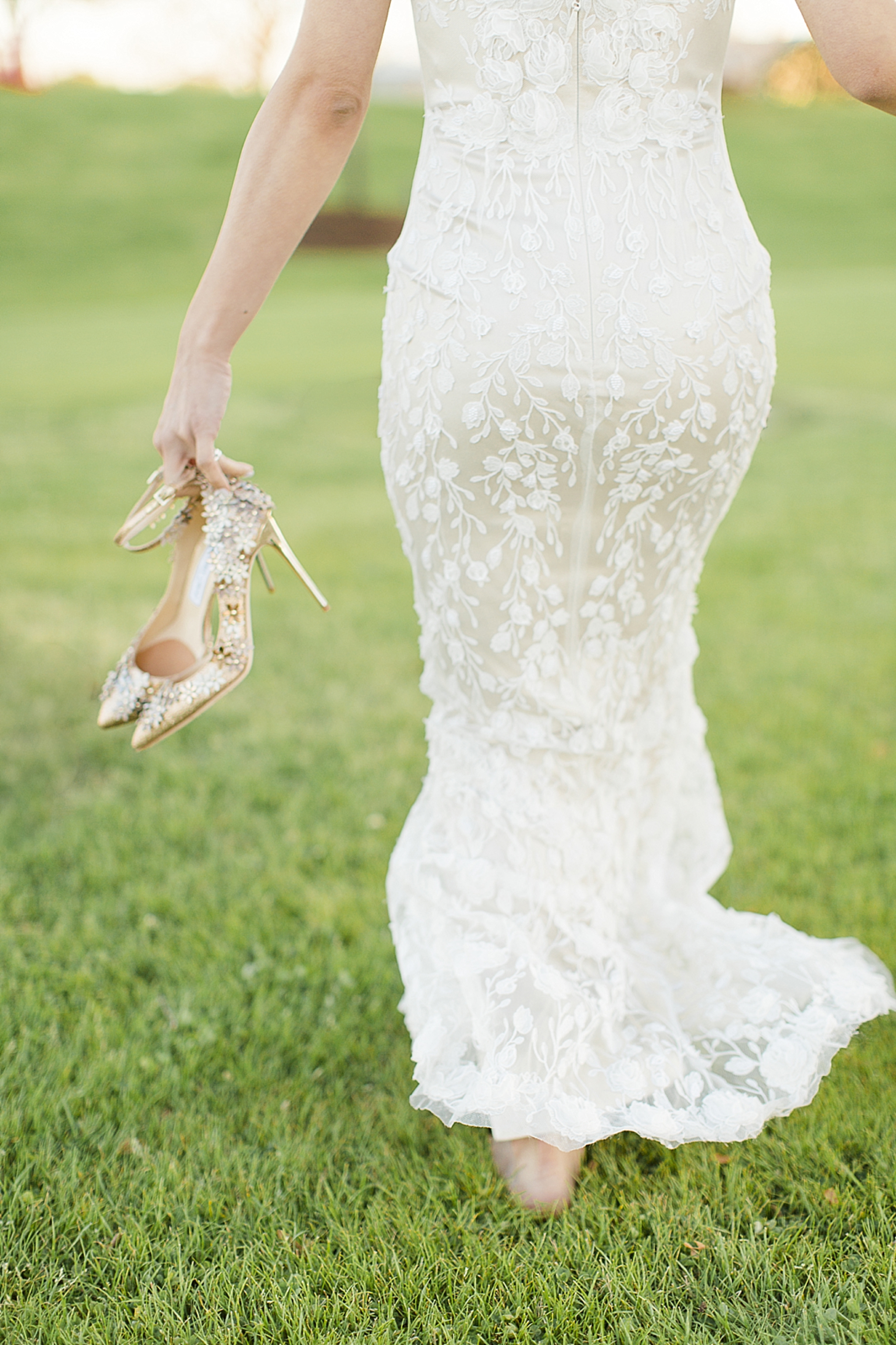 bride walking with shoes in hand
