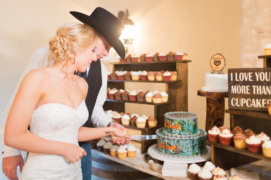 bride and groom cutting camo cake