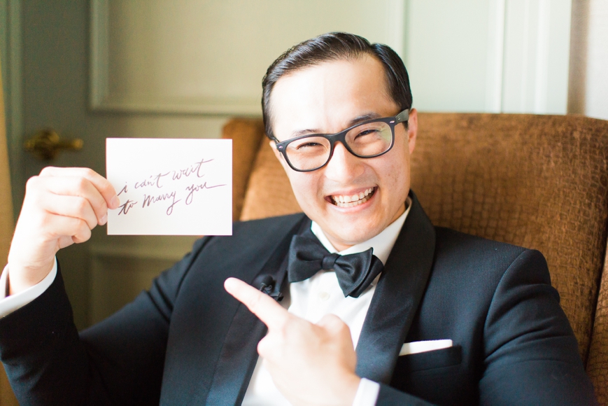 groom smiling holding letter to wife