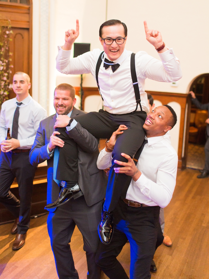 friends lift groom up on their shoulders