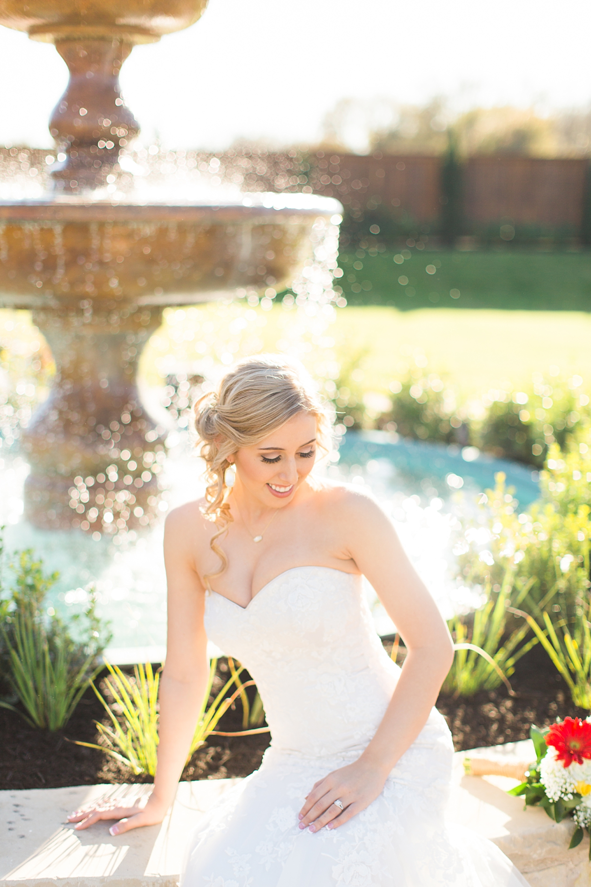 beautiful bride sitting on fountain
