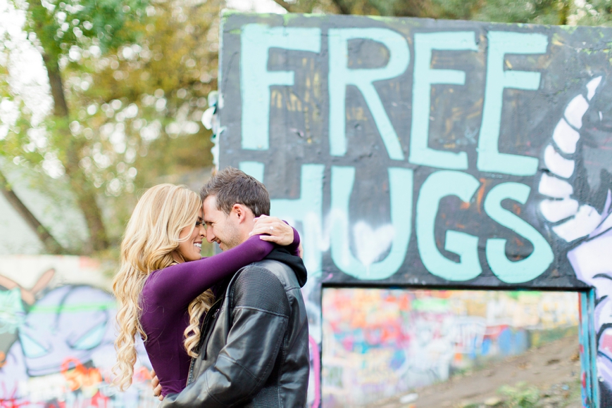 engagement photo free hugs sign