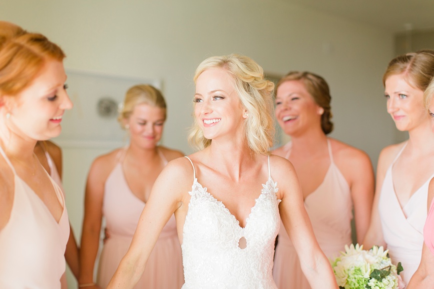 happy bride holding bridesmaids hands