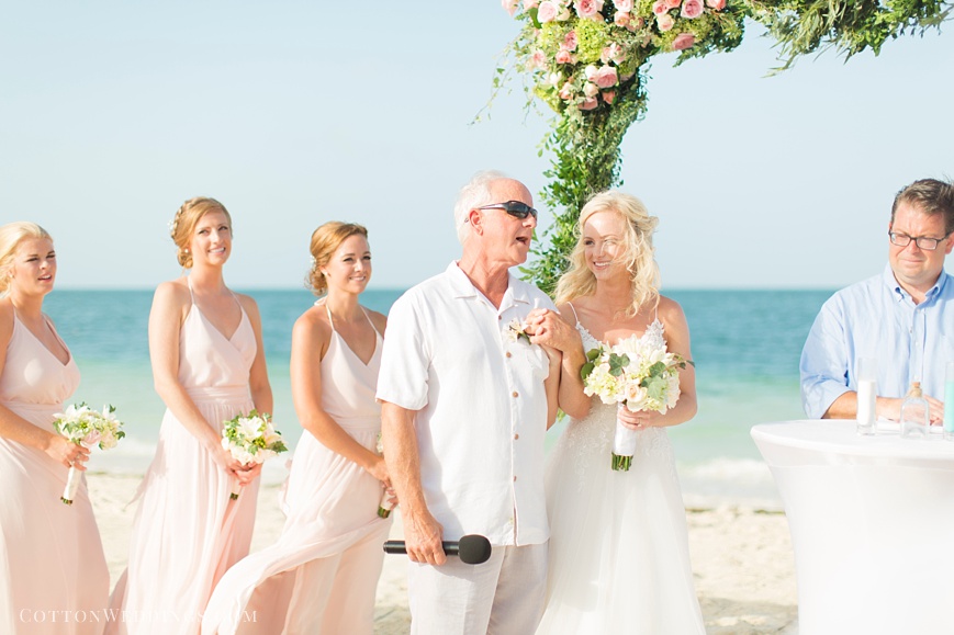 father singing song for bride during beach ceremony