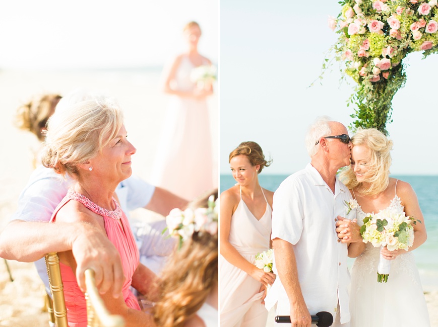 father kissing bride on the forehead during beach wedding