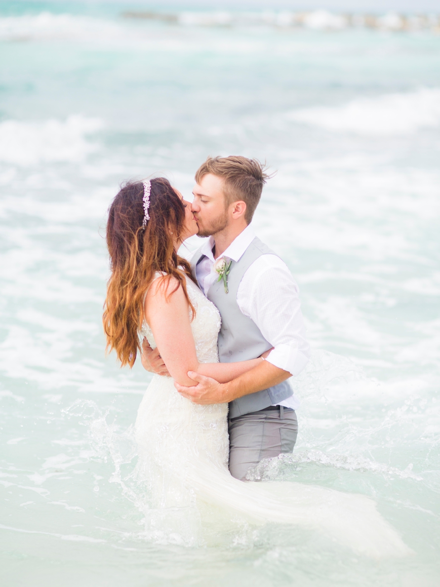 beautiful bride and groom kissing in ocean