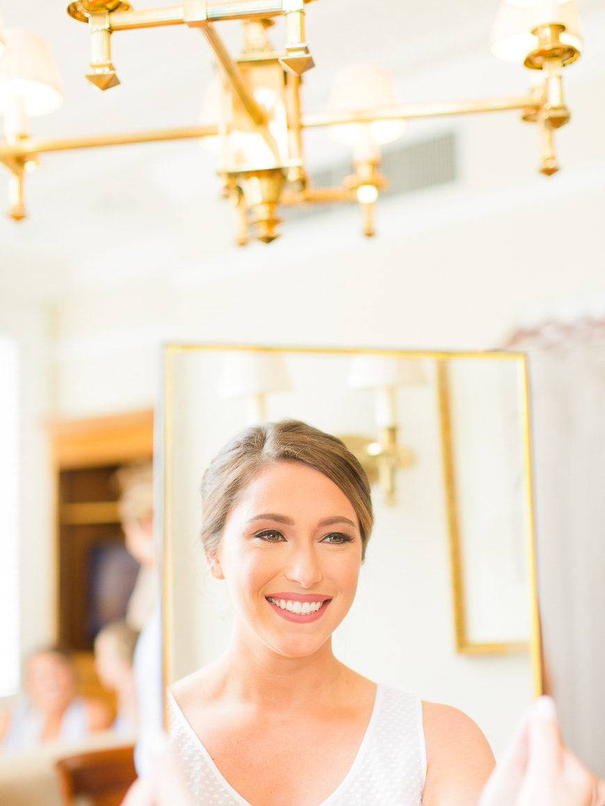 happy bride smiling at herself in mirror