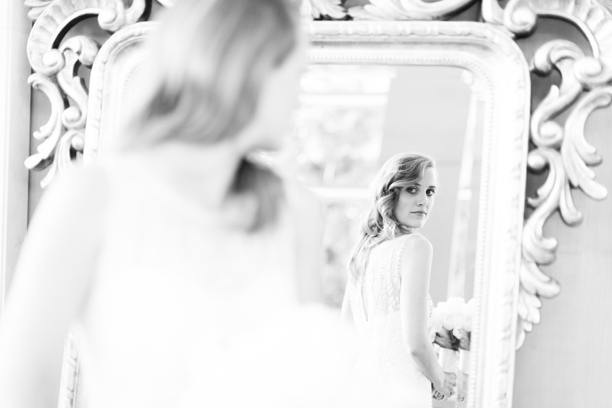 black and white portrait of bride looking in mirror