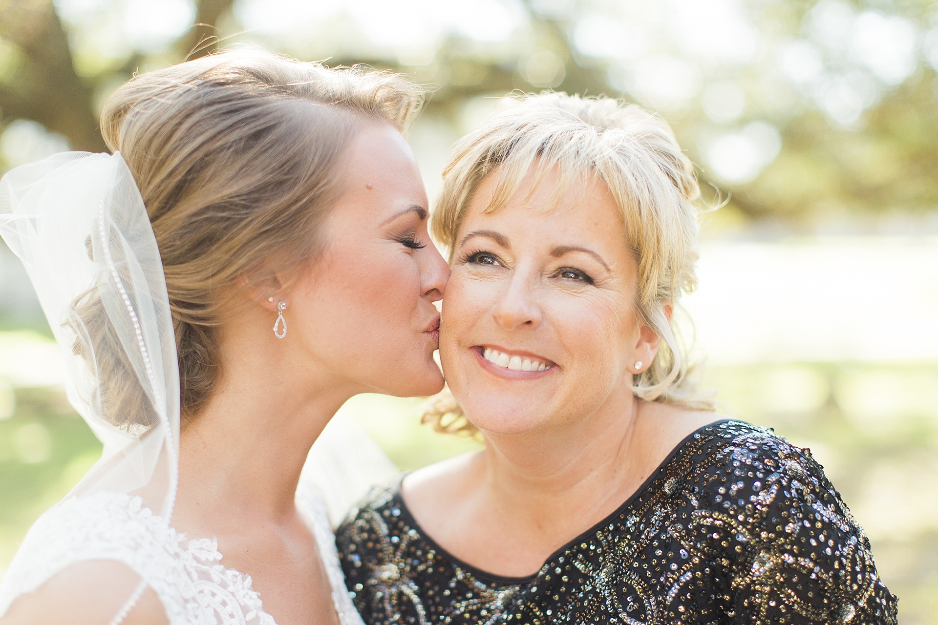 bride kissing mom on cheek