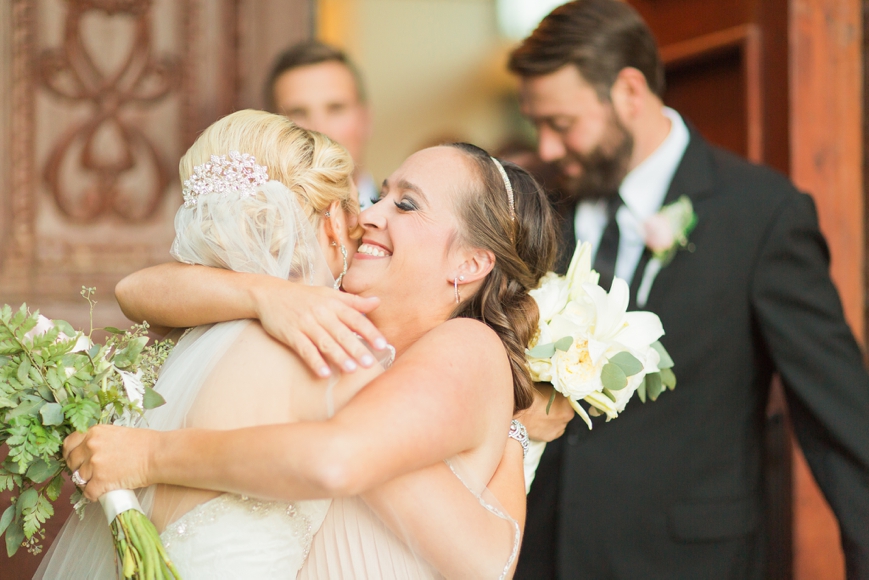 happy bridesmaid hugging bride