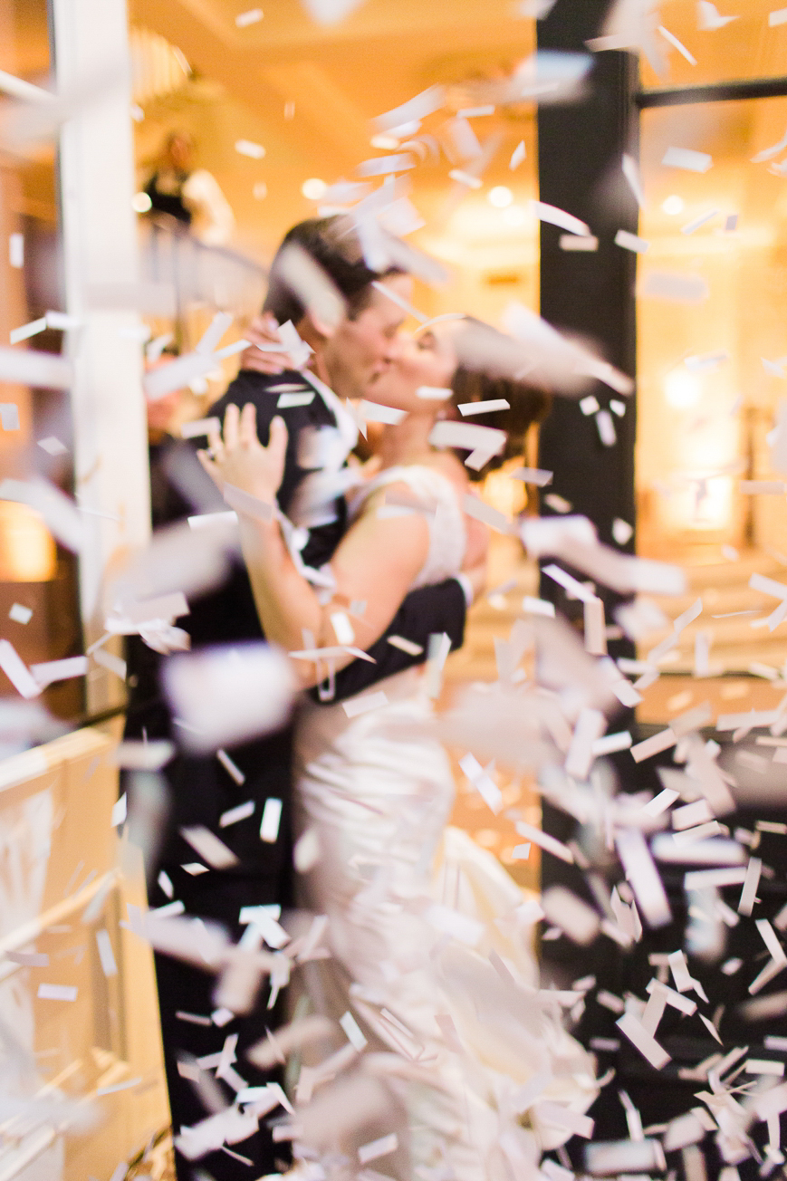 bride and groom kissing confetti exit
