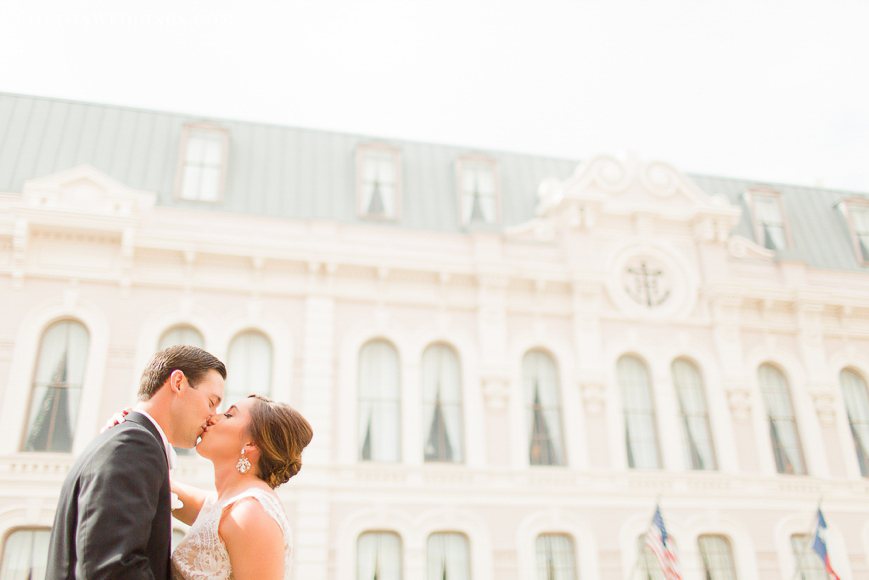  happy bride and groom kissing in front of tremont house galveston